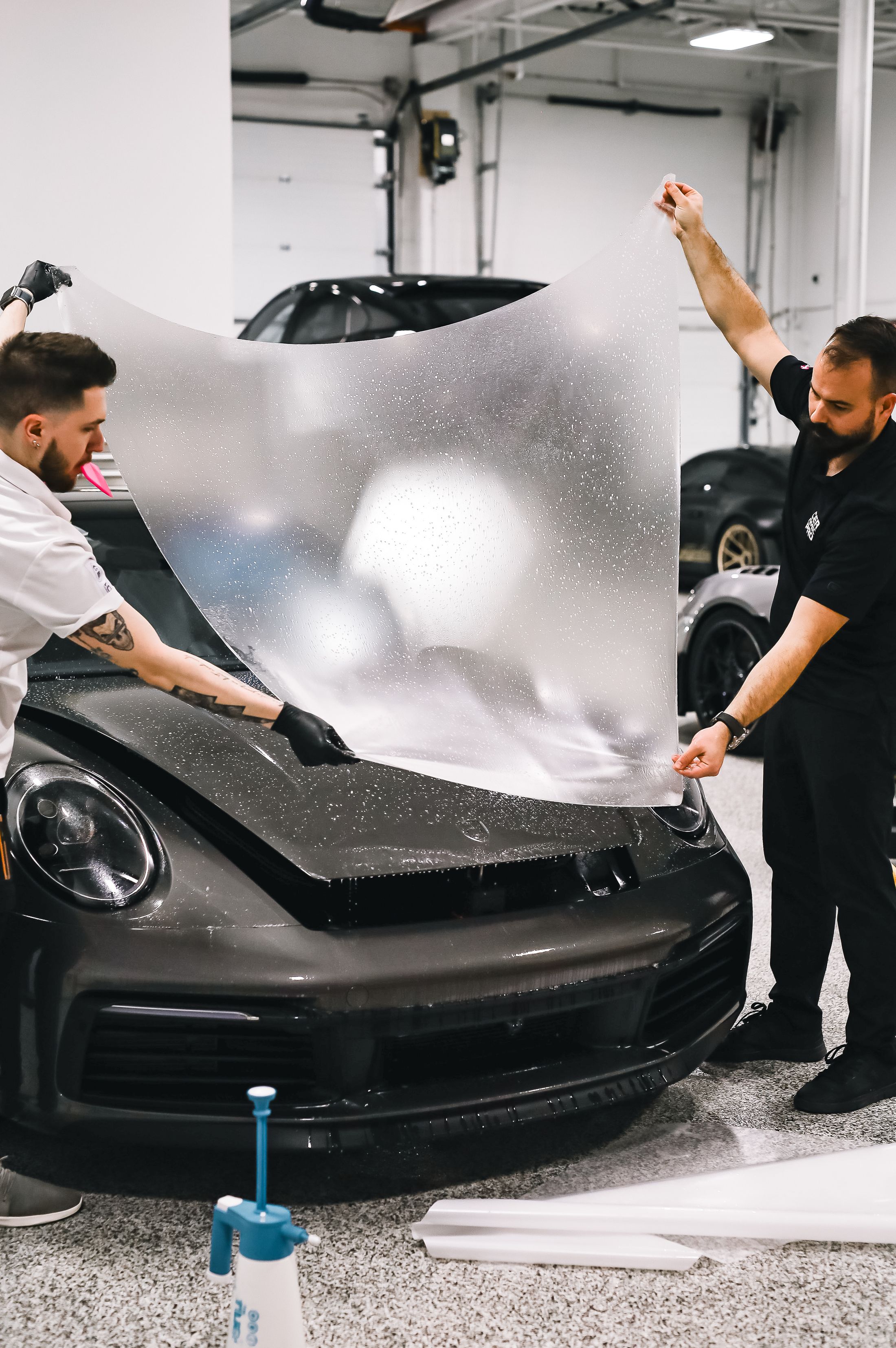 Мастера примеряют защитную плёнку на кузов Porsche